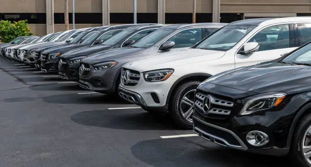 Row of new cars at a dealership lot with the front car in focus