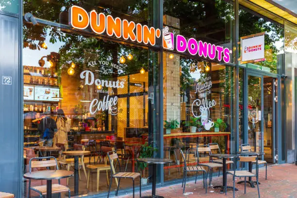 Dunkin' Donuts cafe storefront with outdoor seating and window displays